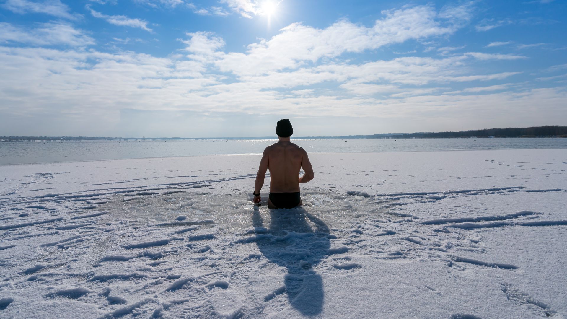 Man takes a cold plunge in an icy lake
