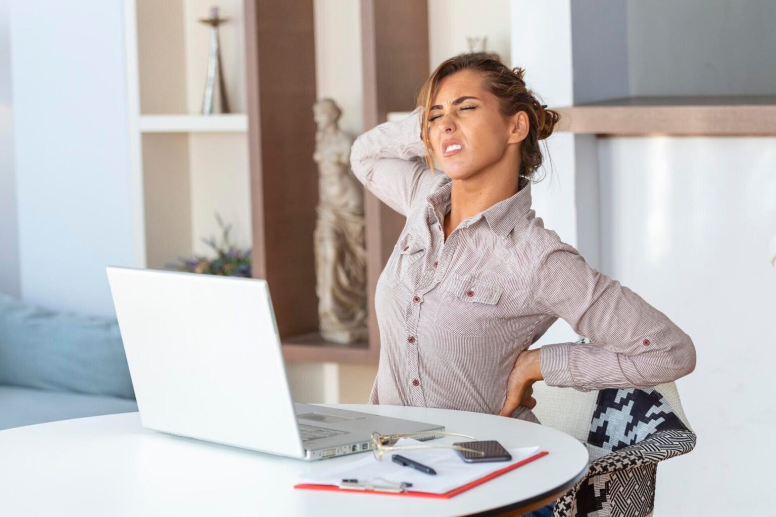 Woman stiff from sedendary lifestyle, in need of infrared sauna session